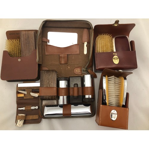 234 - Five vintage men's' vanity cases and clothes brush sets in leather cases.