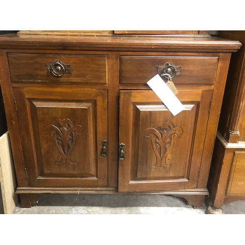 349 - A two-drawer, two-door wooden cabinet with handles. Decorative pattern carved into the door panels w... 