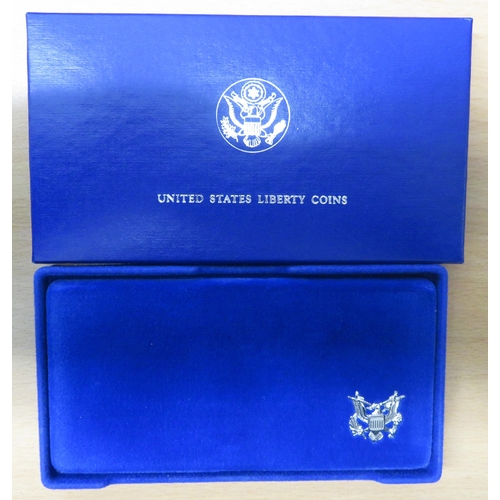 319 - 1986 Liberty silver dollar and (CuNi) half dollar cased set with COA.