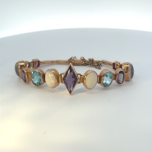 30 - A gold (tests as 9ct)  bracelet set with 13 vari-shaped gemstones, including rhodolite garnet, topaz... 