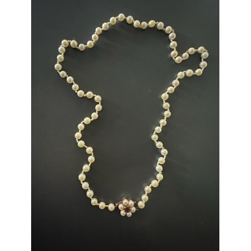 50 - A cultured pearl matinee necklace with a 9ct gold and garnet clasp. 22inches in length.