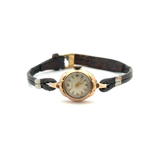 133 - A ladies Marvin 9ct gold watch with leather strap. Arabic numerals at 12, 3 6 and 9 and other hourly... 