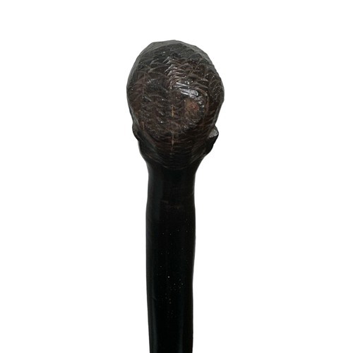 71 - An African carved hardwood twisted walking stick with carved head top. Height 83cm.