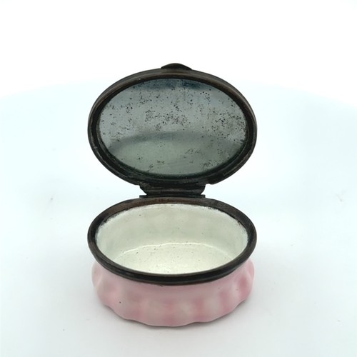 55 - An oval Bilston enamel patch box with light pink fluted base and hingled lid with two coloured love ... 