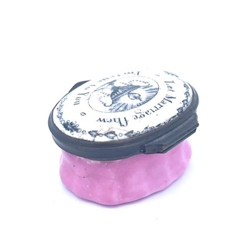 57 - A Bilston oval enamel patch box with a pink fluted base and a hinged monochrome lid with the motto '... 