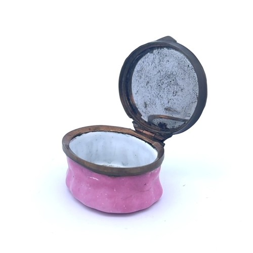 57 - A Bilston oval enamel patch box with a pink fluted base and a hinged monochrome lid with the motto '... 