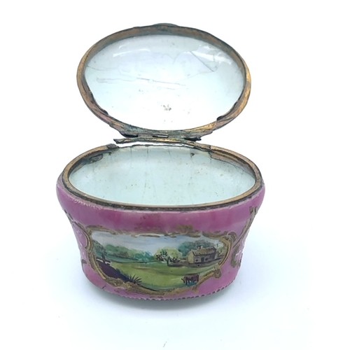 61 - An enamel hand painted pink enamel patch box, probably Bilston with a hinged lid (some damage to met... 