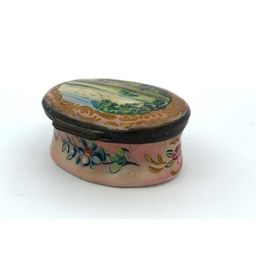 62 - A Battersea/ Bilston hand painted enamel patch box with hinged lid depicting a rural scene and a flo... 