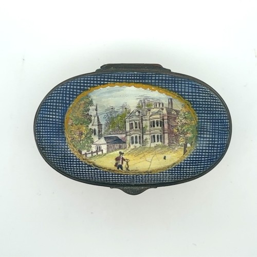 63 - An oval enamel pill/ patch box, probably Bilston with fluted body and painted lid depicting a church... 