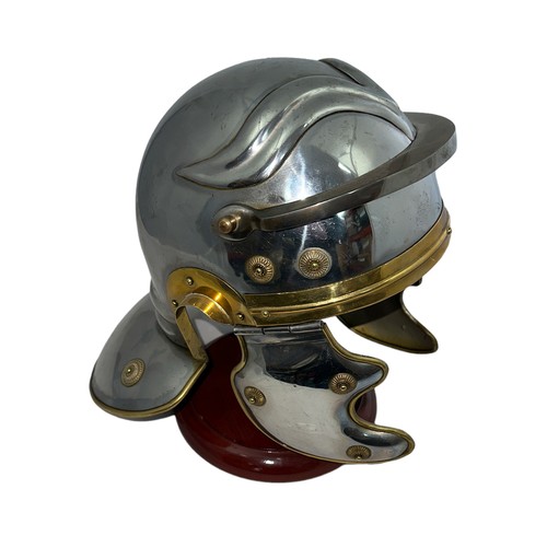 150 - A reproduction Roman Legionary military helmet, with visor and side-flaps. Steel with brass detailin... 