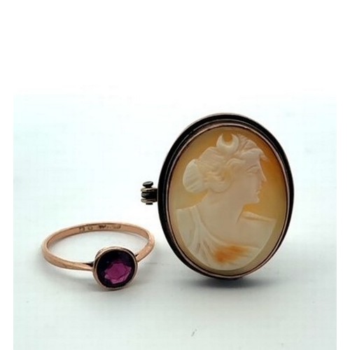 45 - A pyrope garnet set in a 9ct gold ring (scratches and wear on garnet). A shell cameo brooch in a (te... 