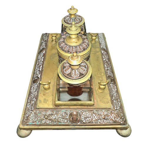 424 - A brass decorative desk tidy with three inkwells, two glass (one damaged). With decorative dragonfly... 