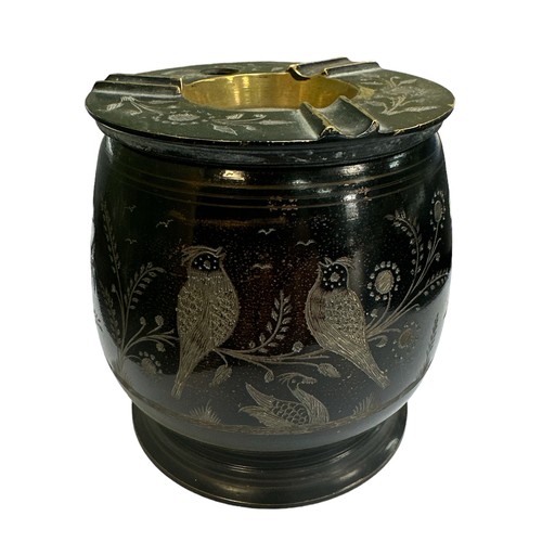 139 - A black painted brass cigarette dispenser / ashtray with floral and bird design carved into the exte... 