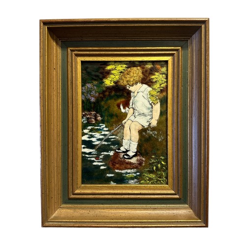 369 - Susan Searle – An aesthetic pictorial enamel framed plaque by Susan Searle depicting a young boy fis... 