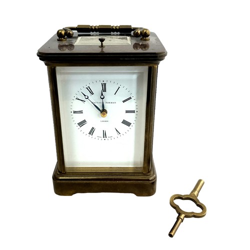 126 - A brass cased carriage clock with bevelled glass panels, Matthew Norman of London, complete with key... 