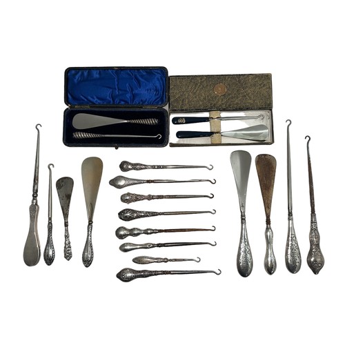 504 - A collection of silver handled button hooks (15) and shoe horns (4), with two boxed silver plated tw... 