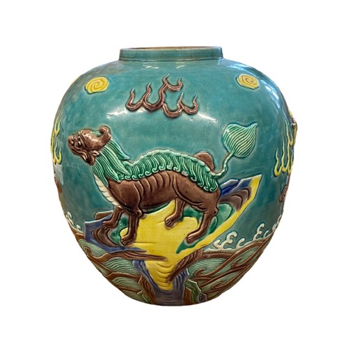 86 - A large turquoise coloured oriental ginger jar with raised decoration featuring two dragons and a wi... 