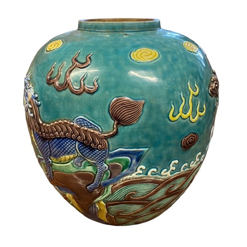 86 - A large turquoise coloured oriental ginger jar with raised decoration featuring two dragons and a wi... 