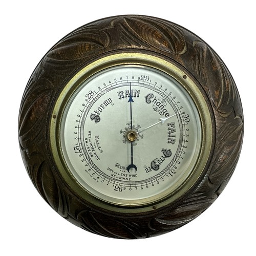 118 - A 20th century wall barometer, round in carved wooden case. British Made. Diameter 23cm.