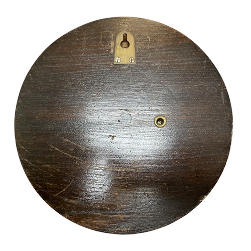 118 - A 20th century wall barometer, round in carved wooden case. British Made. Diameter 23cm.