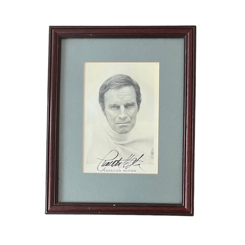 547 - Charlton Heston (1923-2008) – A framed black and white photograph signed by Charlton Heston in black... 