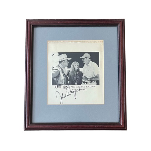 553 - John Wayne (1907-1979) – A framed black and white photograph signed by John Wayne in black ink “Good... 