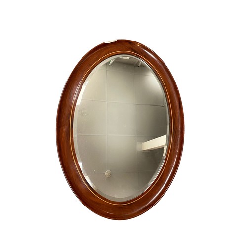 402 - Mahogany framed oval mirror, with inlaid band, 87cm x 63cm, area of damage to edge on one side.