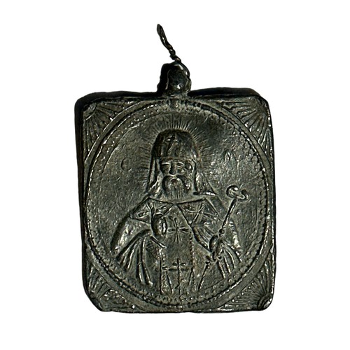 23 - Pewter lidded jug (height 26cm) with two-sided religious token (possibly lead) 6cm x 5cm.