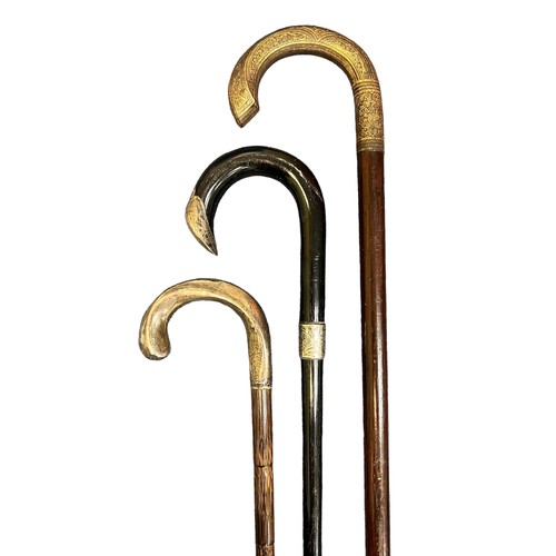 306 - Collection of eleven walking sticks, including one with a brass duck head handle, one with a brass h... 