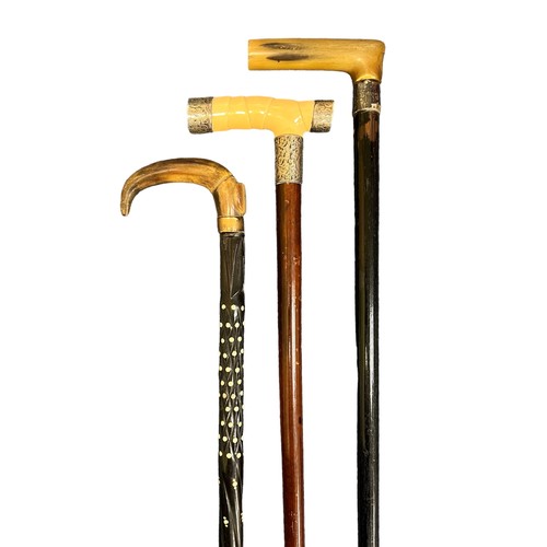 306 - Collection of eleven walking sticks, including one with a brass duck head handle, one with a brass h... 