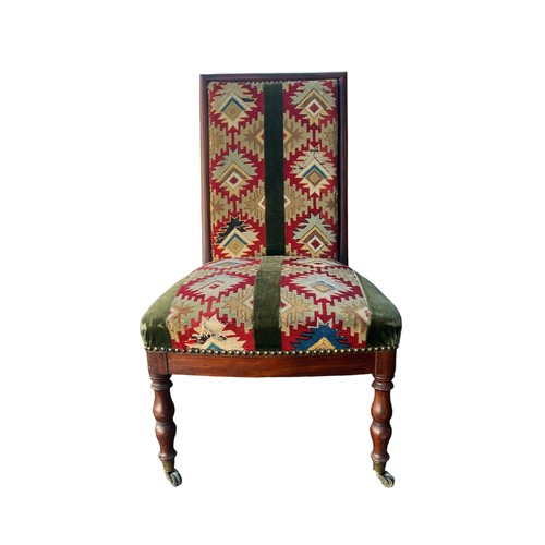 324 - Mahogany chair with kilim upholstery on turned legs with brass casters to front, height 87cm.