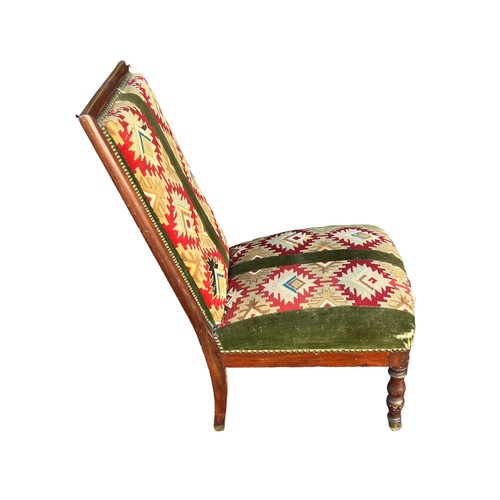 324 - Mahogany chair with kilim upholstery on turned legs with brass casters to front, height 87cm.