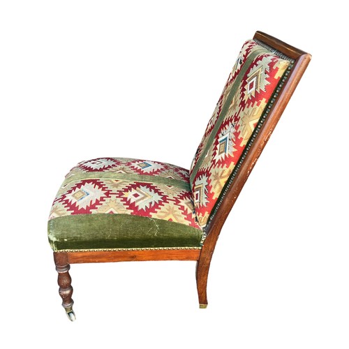 324 - Mahogany chair with kilim upholstery on turned legs with brass casters to front, height 87cm.