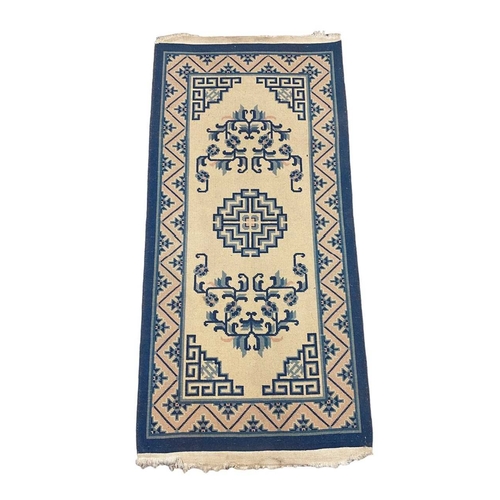 264A - A Chinese ‘Peking’ blue and white rug. Approx 150cm x 70cm.