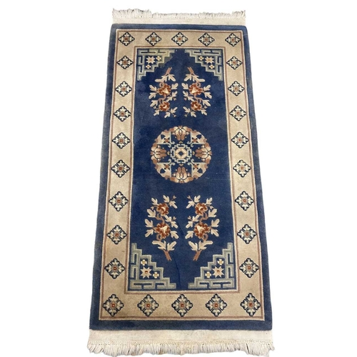 265A - A pair of blue and white (cream) rugs, oriental in style. Both approx. 150cm x 70cm.