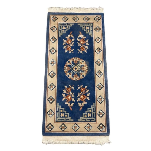 265A - A pair of blue and white (cream) rugs, oriental in style. Both approx. 150cm x 70cm.