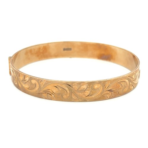 397 - A 9ct gold foliate engraved hinged bangle. Hallmarks for Birmingham. Weight approx 19.13g