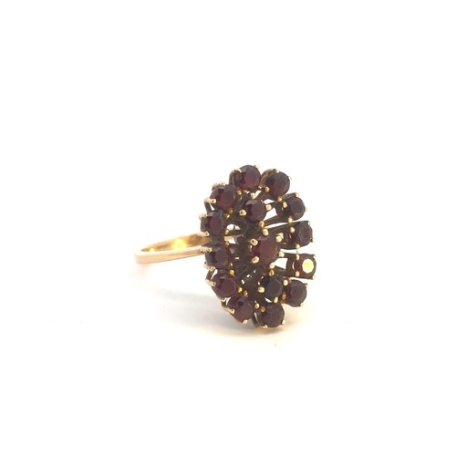 517 - A large garnet cluster ring, stamped 750. Size P.
Weight 5.5g.