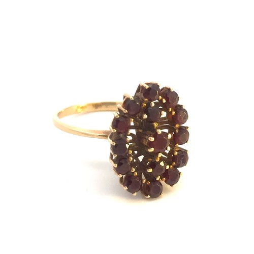 517 - A large garnet cluster ring, stamped 750. Size P.
Weight 5.5g.