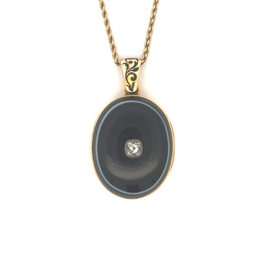 398 - A jet and diamond mourning locket. The oval locket, made from unmarked gold (tests as 14 to 18ct), i... 