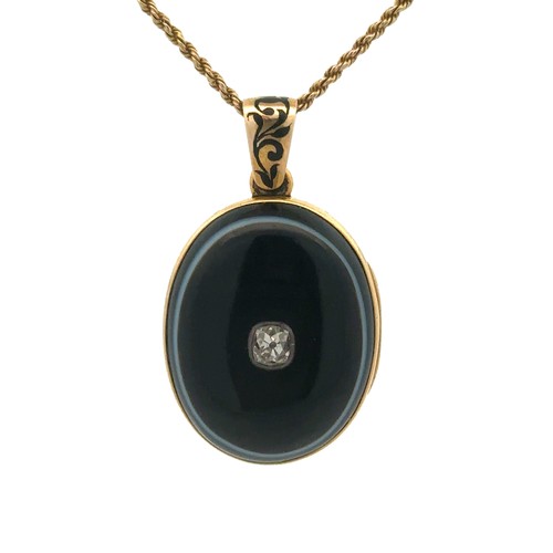 398 - A jet and diamond mourning locket. The oval locket, made from unmarked gold (tests as 14 to 18ct), i... 