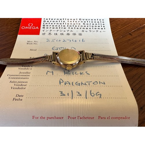 558 - Omega 9ct gold ladies wristwatch and bracelet, in branded box of issue with booklet/certificate date... 