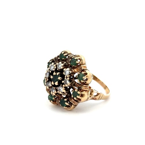 425 - A gold dress ring stamped 14K set with emeralds and diamonds in a flower design. Size M.