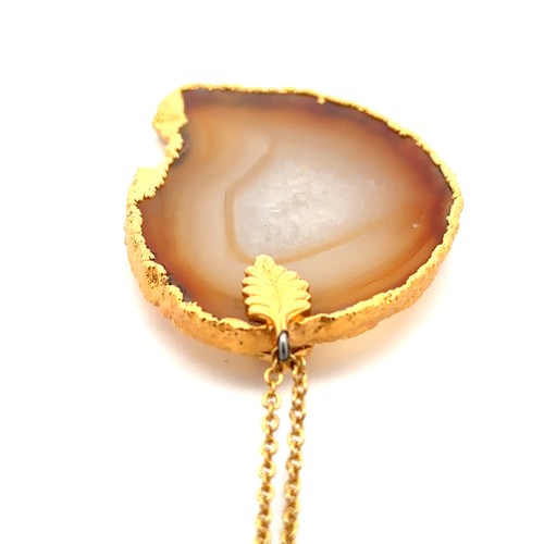 429 - An agate pendant, 43mm in length, in a yellow metal mount with a leaf design. Suspended from a yello... 