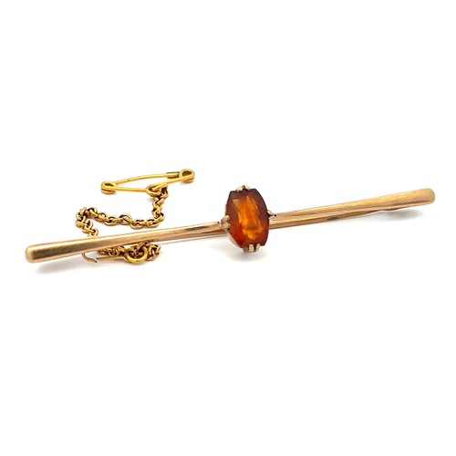 418 - A citrine bar brooch, stamped 9CT. Attached is a yellow metal safety chain. Citrine in good conditio... 