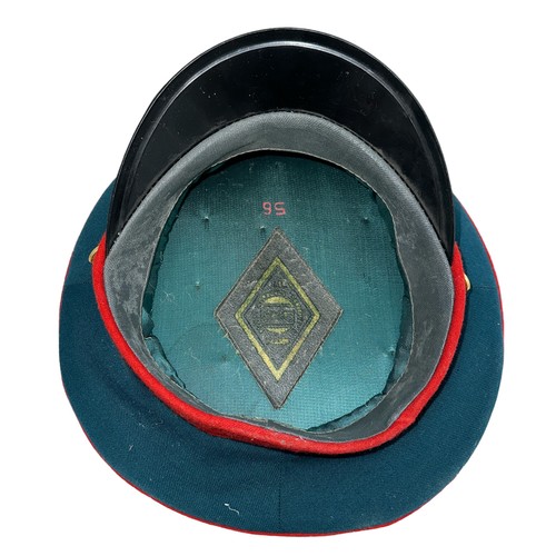 43 - Russian green and red police hat, with an interesting selection of Russian enamelled badges affixed ... 