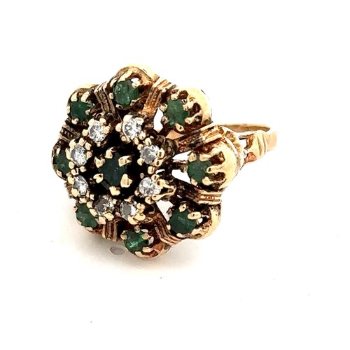 425 - A gold dress ring stamped 14K set with emeralds and diamonds in a flower design. Size M.