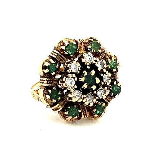 425 - A gold dress ring stamped 14K set with emeralds and diamonds in a flower design. Size M.