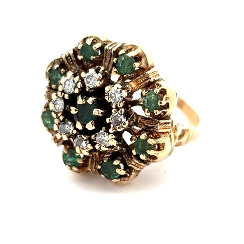 425 - A gold dress ring stamped 14K set with emeralds and diamonds in a flower design. Size M.