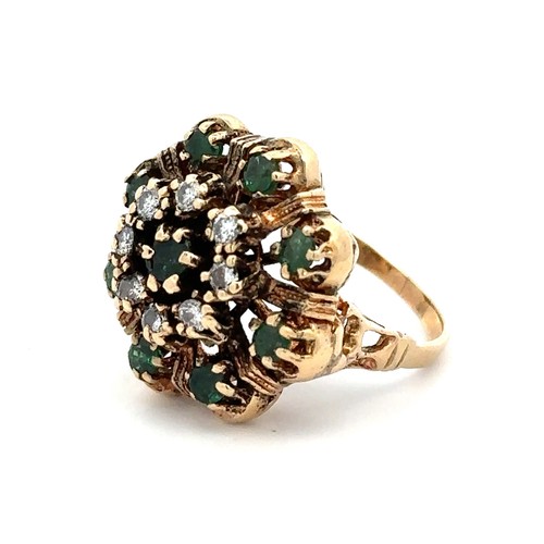 425 - A gold dress ring stamped 14K set with emeralds and diamonds in a flower design. Size M.